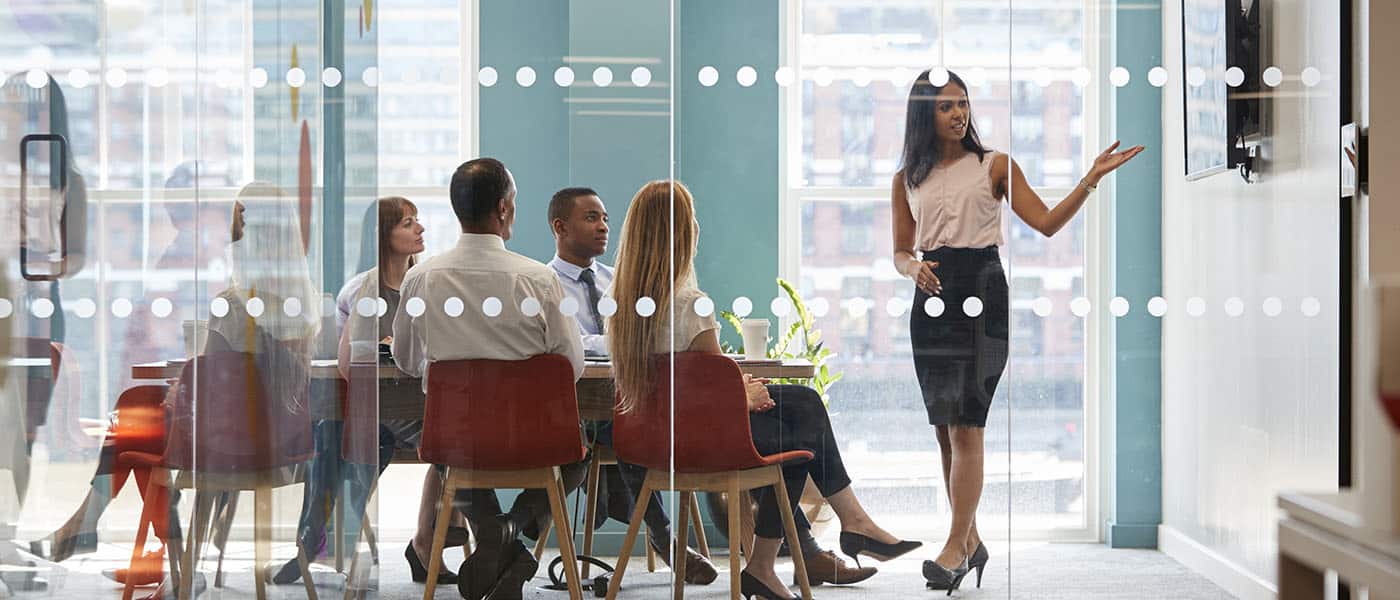 Female boss shows presentation on screen at business meeting